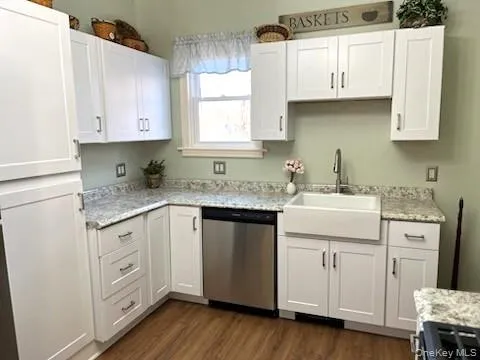 a kitchen with white cabinets and sink