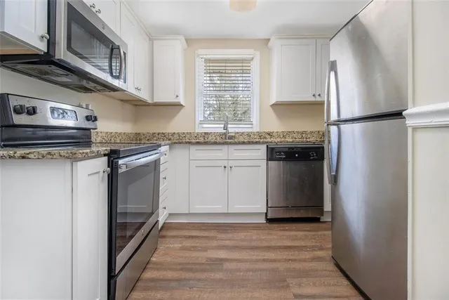 a kitchen with stainless steel appliances granite countertop a stove a refrigerator and a microwave