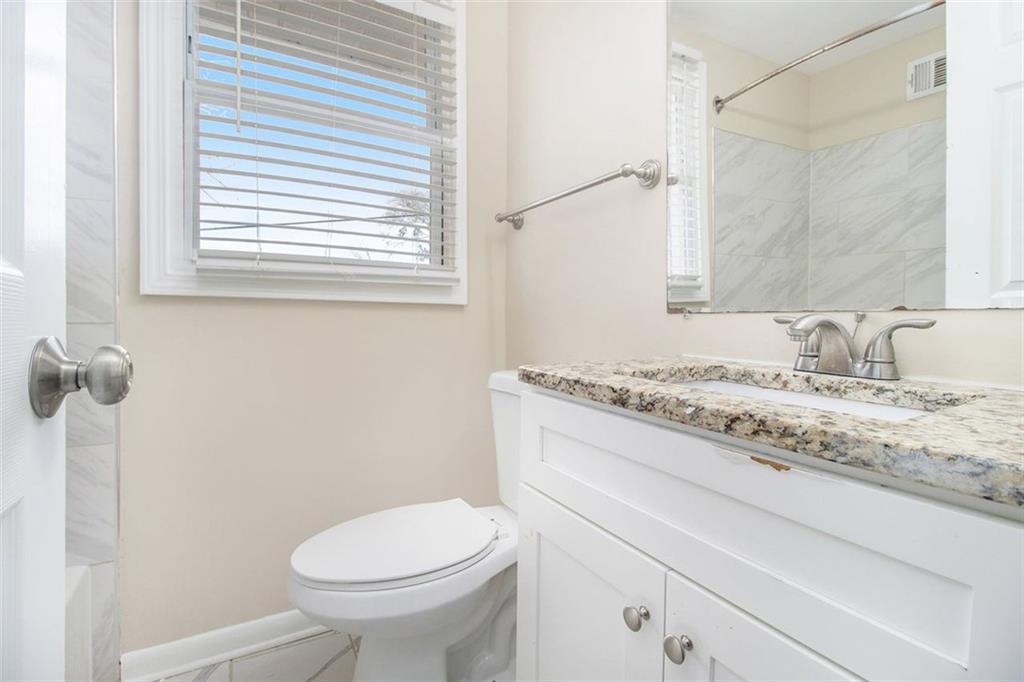 3409 Glensford Drive Decatur, GA 30032 - Photo 9 of 15 a bathroom with a granite countertop toilet sink and mirror