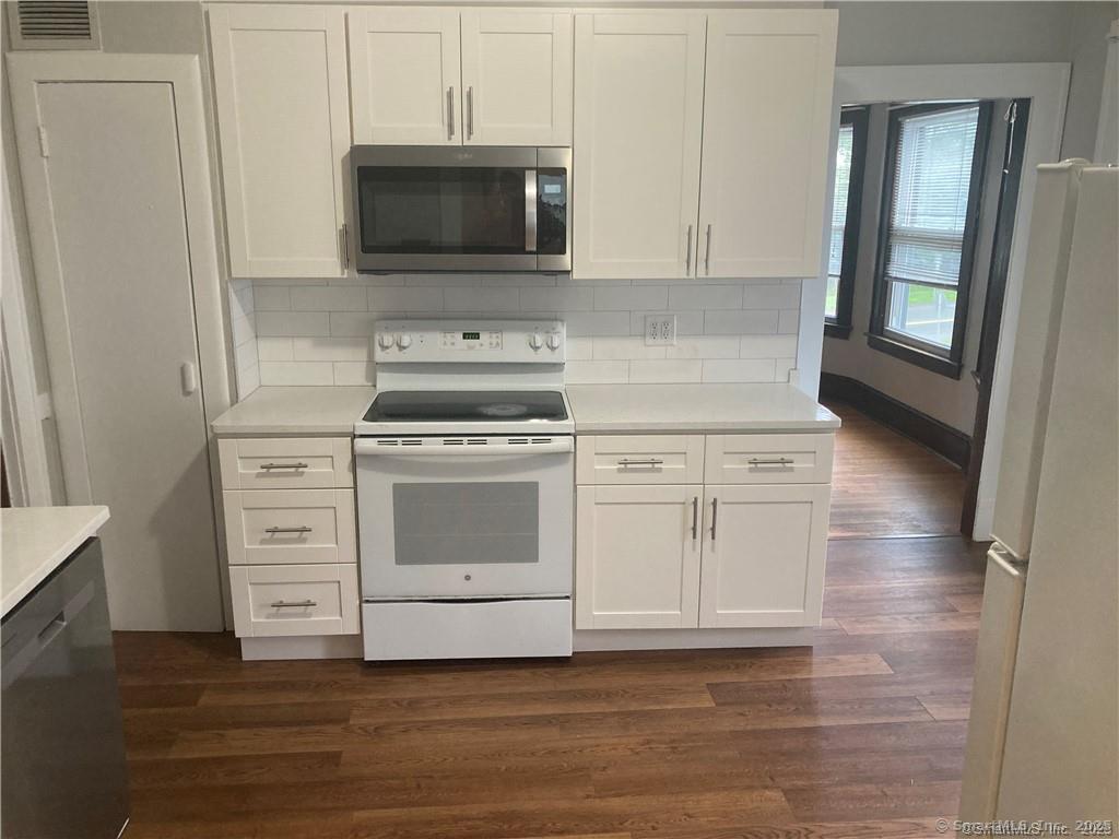 193-195 Wolcott Hill Road Wethersfield, CT 06109 - Photo 19 of 29 a kitchen with white cabinets and stainless steel appliances