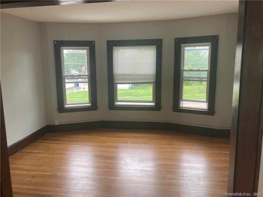 193-195 Wolcott Hill Road Wethersfield, CT 06109 - Photo 21 of 29 a view of an empty room with wooden floor and a window
