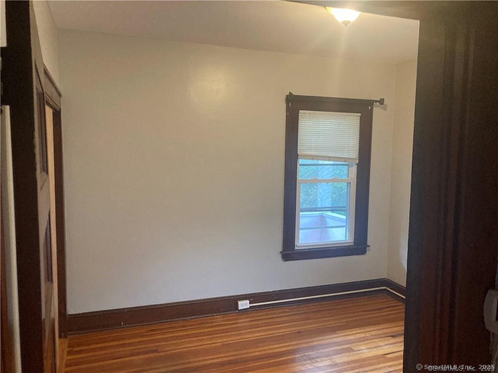 193-195 Wolcott Hill Road Wethersfield, CT 06109 - Photo 27 of 29 a view of an empty room with wooden floor and a window