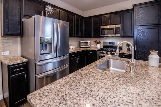 a kitchen with sink stove and refrigerator