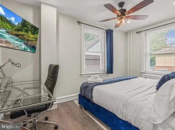 a bedroom with a bed a chair and a large window