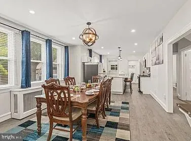 a view of a dining room and livingroom with furniture front door and wooden floor