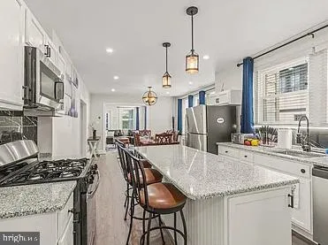 a kitchen with stainless steel appliances granite countertop a sink a stove and a refrigerator