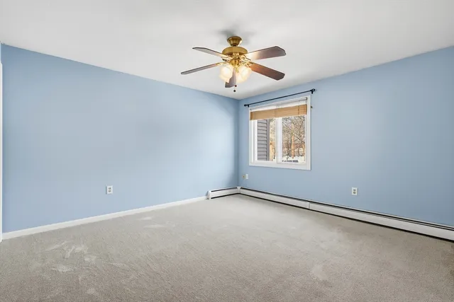 a view of an empty room and chandelier fan