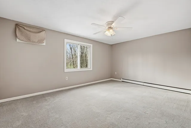 a view of an empty room with a ceiling fan