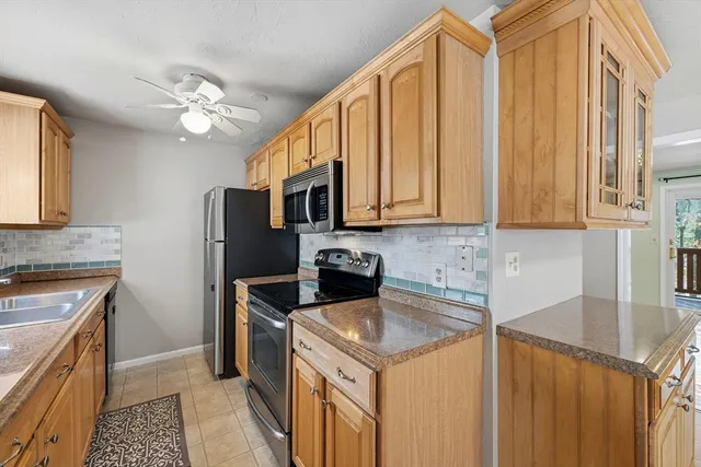 a kitchen with stainless steel appliances granite countertop a sink a stove and a refrigerator