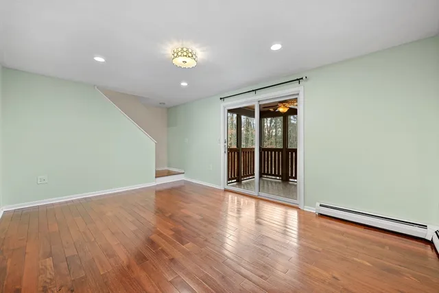 an empty room with wooden floor and natural light