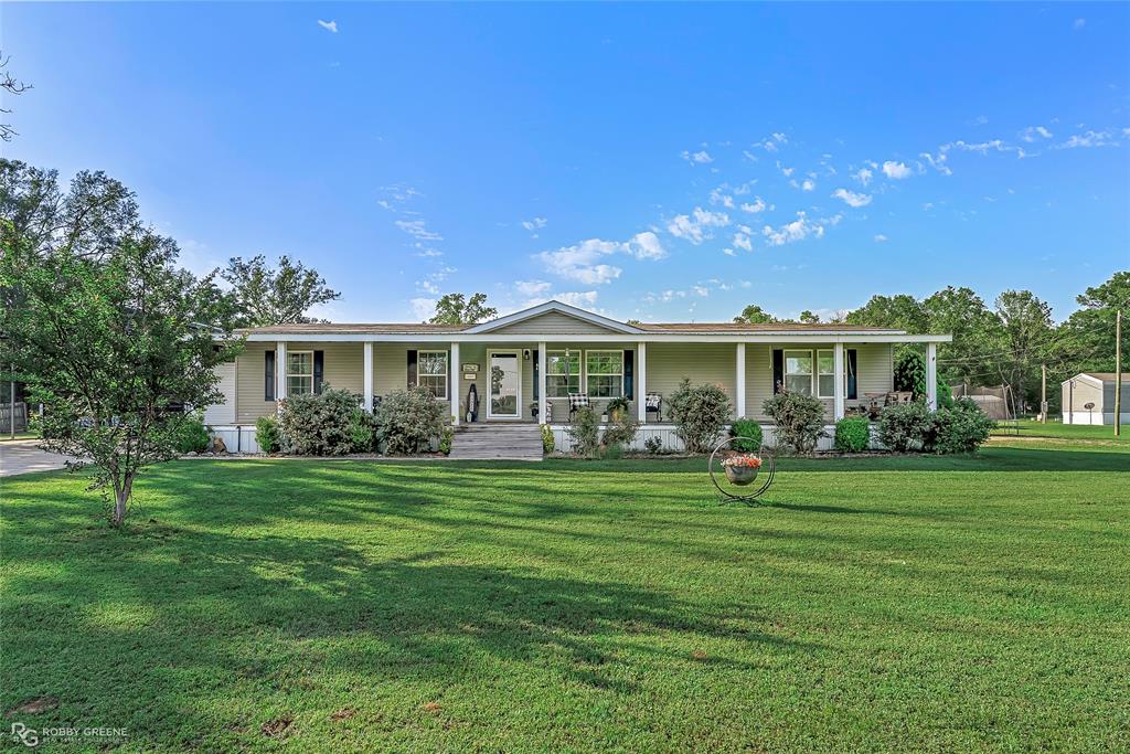 Ranch-style house with covered porch and a front lawn