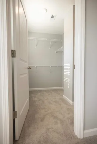 a view of an empty room and chandelier fan