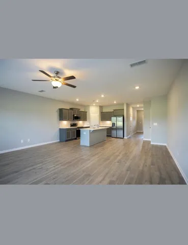 a living room with furniture and kitchen view