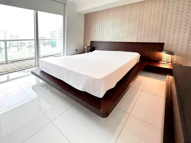 a bedroom with a bed and large window