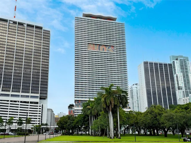 a front view of a building with palm trees