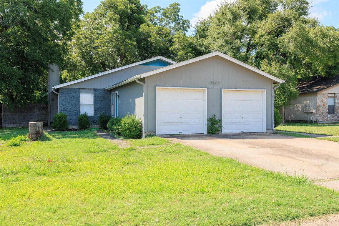 12507 Turtle Rock Road, Unit A Austin, TX 78729 - Photo 1 of 1 a view of yellow house with a yard plants and large tree