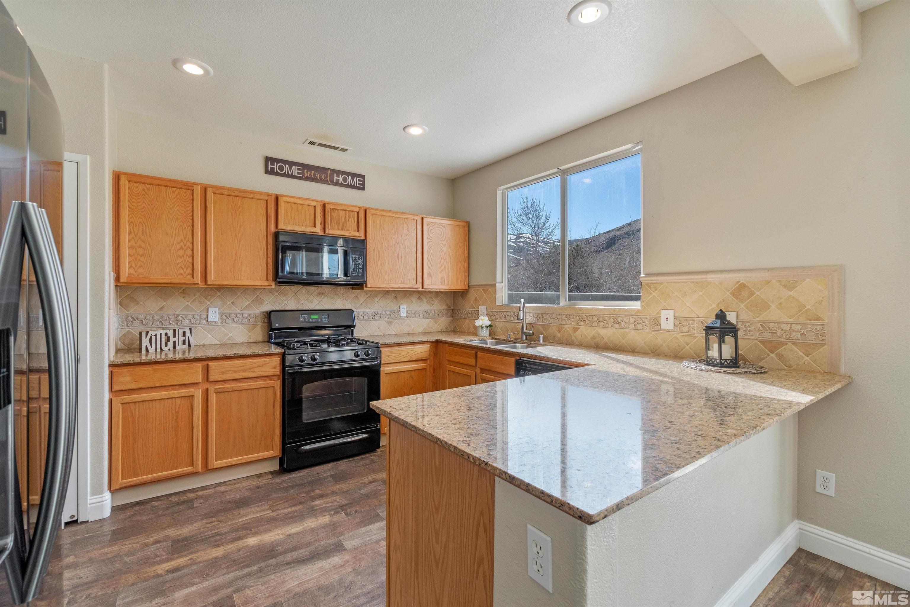 8707 Malibu Drive Reno, NV 89506 - Photo 13 of 35 a kitchen with stainless steel appliances granite countertop a sink dishwasher stove and refrigerator