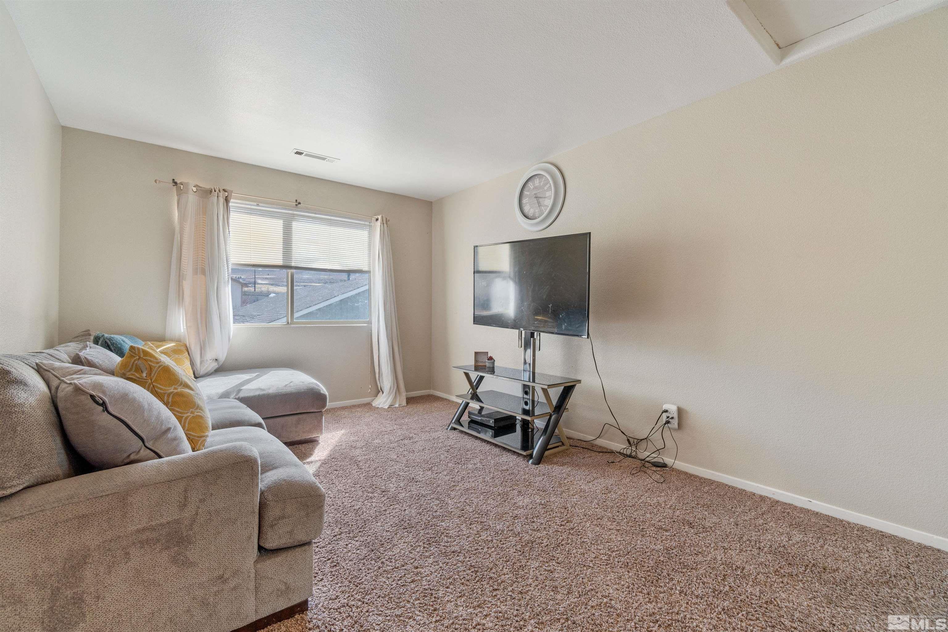8707 Malibu Drive Reno, NV 89506 - Photo 21 of 35 a living room with furniture a flat screen tv and a window