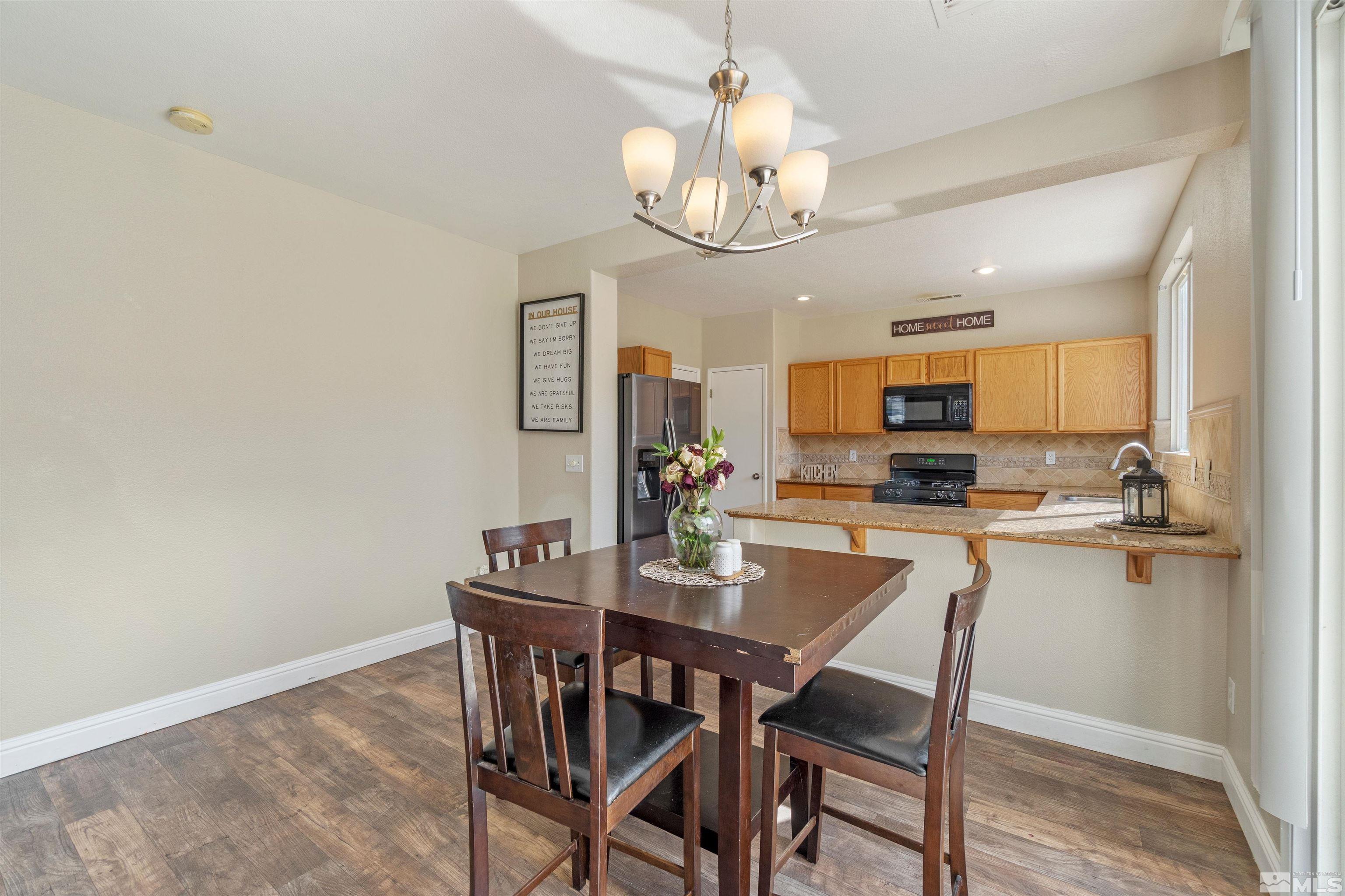 8707 Malibu Drive Reno, NV 89506 - Photo 10 of 35 a view of a dining room with furniture a chandelier and wooden floor