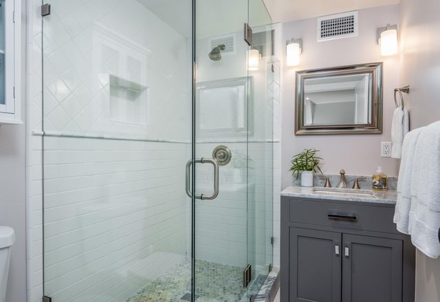 a bathroom with a sink a mirror a vanity and shower
