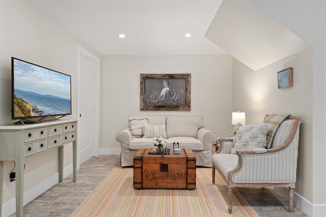 a living room with furniture a flat screen tv and kitchen view