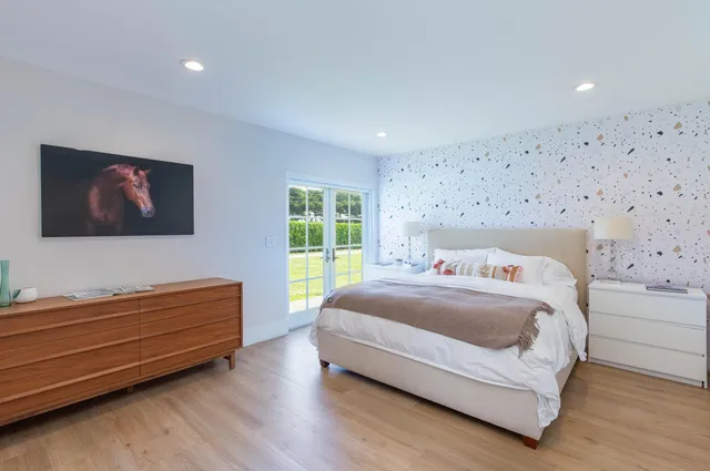 a bedroom with a bed and a flat screen tv