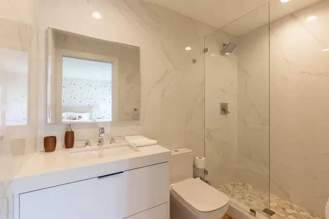 a bathroom with a sink a toilet and shower