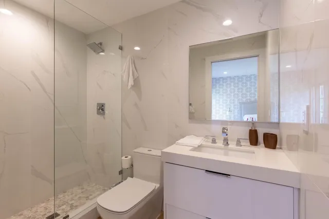 a bathroom with a sink a toilet and shower