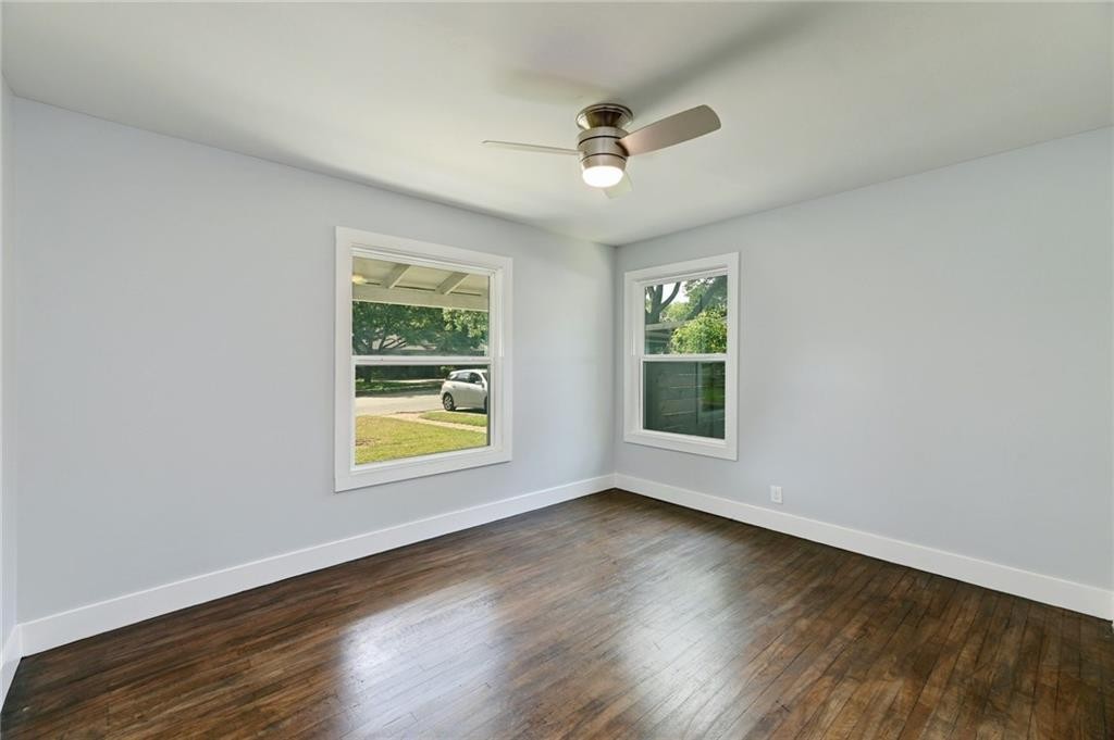 8318 Burrell Drive Austin, TX 78757 - Photo 19 of 27 Unfurnished room featuring dark wood-style floors and a ceiling fan