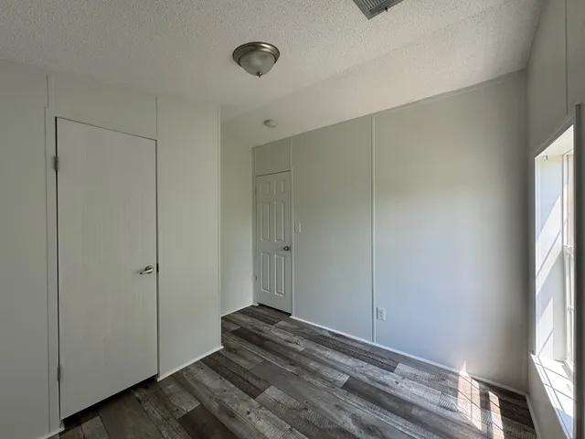 a view of a room with wooden floor and a window