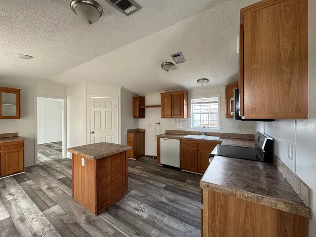 a kitchen with a refrigerator sink and wooden cabinets