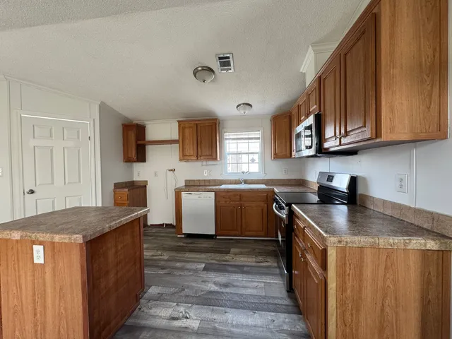 a kitchen with stainless steel appliances granite countertop a sink stove microwave and cabinets