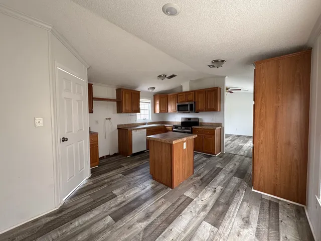 a kitchen with stainless steel appliances granite countertop a refrigerator and a stove top oven