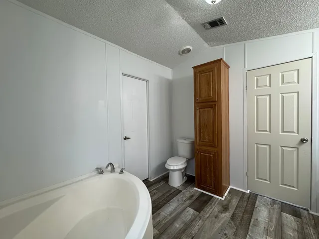 a spacious bathroom with a granite countertop toilet and sink