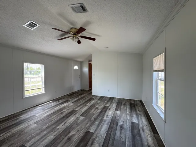 wooden floor in an empty room with a window
