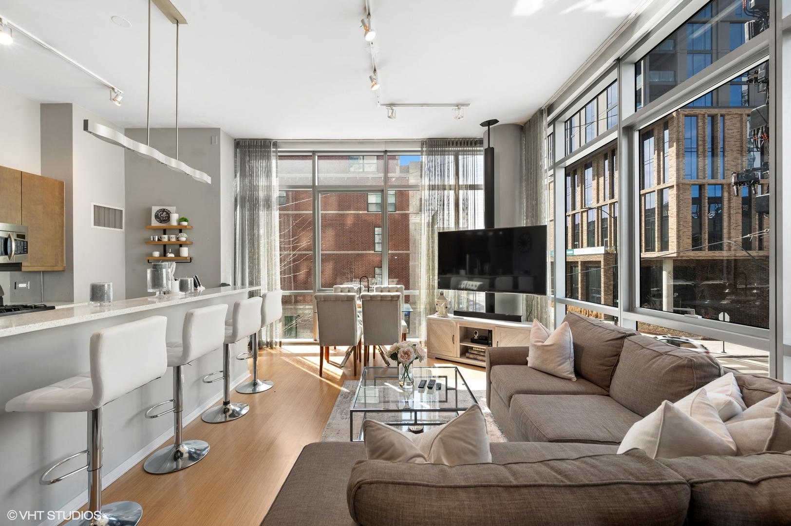 123 South Green Street, Unit 201B Chicago, IL 60607 - Photo 7 of 19 a living room with furniture a flat screen tv and a floor to ceiling window