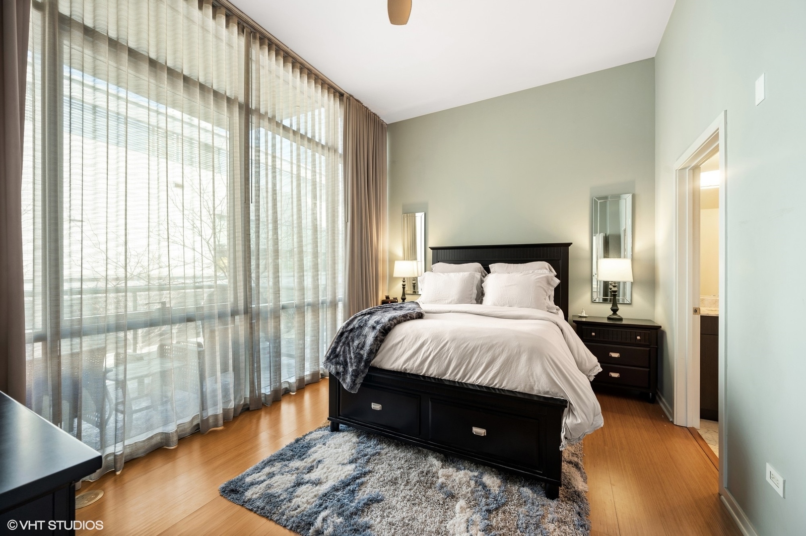 123 South Green Street, Unit 201B Chicago, IL 60607 - Photo 10 of 19 a bedroom with a bed and wooden floor