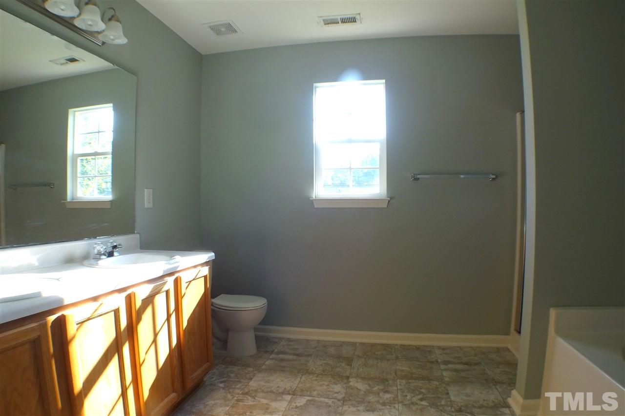 3813 Tyler Bluff Lane Raleigh, NC 27616 - Photo 15 of 25 a bathroom with a sink toilet and window