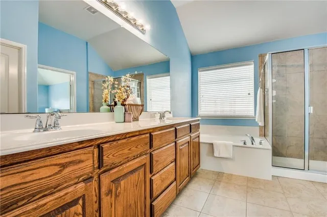 a spacious bathroom with a granite countertop sink a mirror and a bathtub