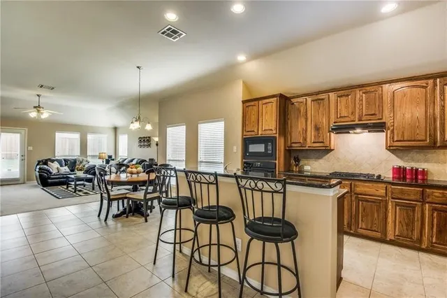 a kitchen with a table chairs stove and cabinets