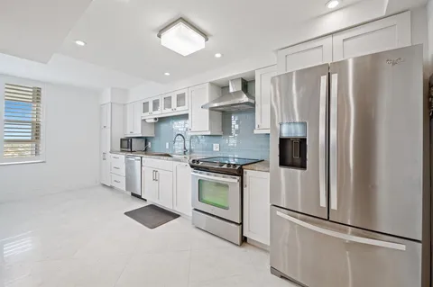 a kitchen with white cabinets and white appliances