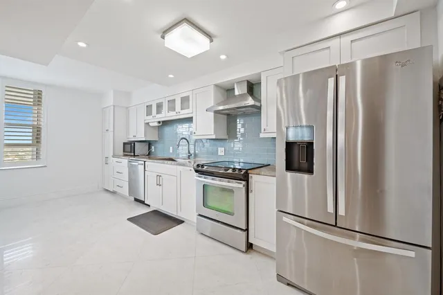 a kitchen with white cabinets and white appliances
