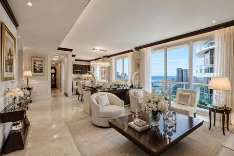 a living room with furniture kitchen view and a chandelier