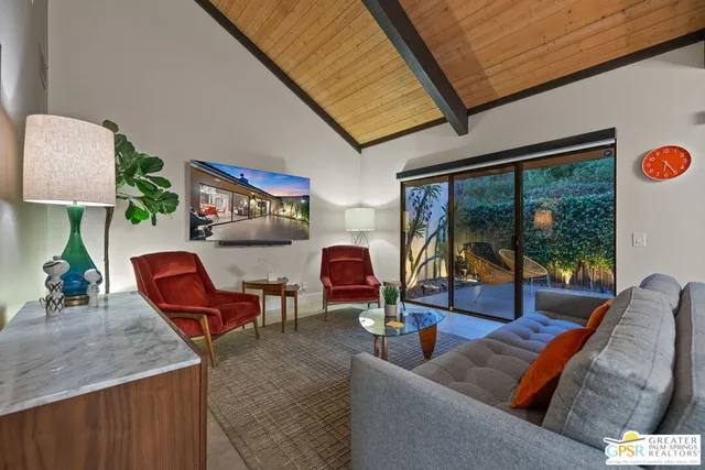 a dining room with furniture potted plants and a chandelier