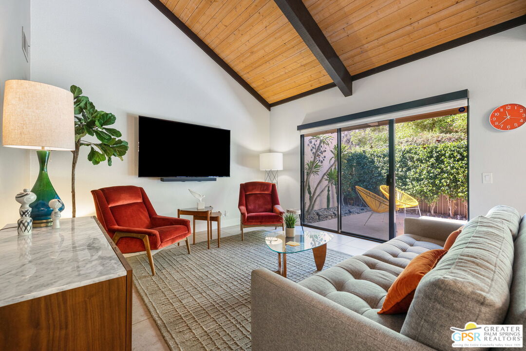 70100 Mirage Cove Drive, Unit 10 Rancho Mirage, CA 92270 - Photo 36 of 68 a living room with furniture a flat screen tv and a large window
