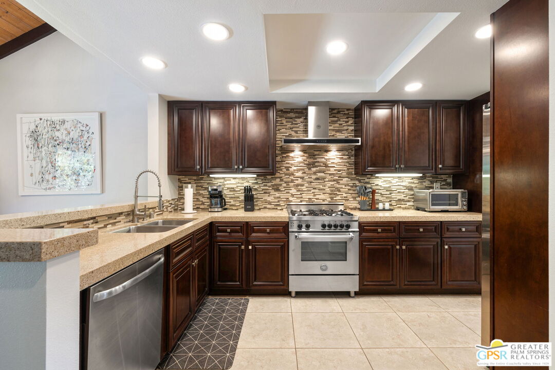70100 Mirage Cove Drive, Unit 10 Rancho Mirage, CA 92270 - Photo 44 of 68 a kitchen with stainless steel appliances granite countertop wooden cabinets a sink and dishwasher