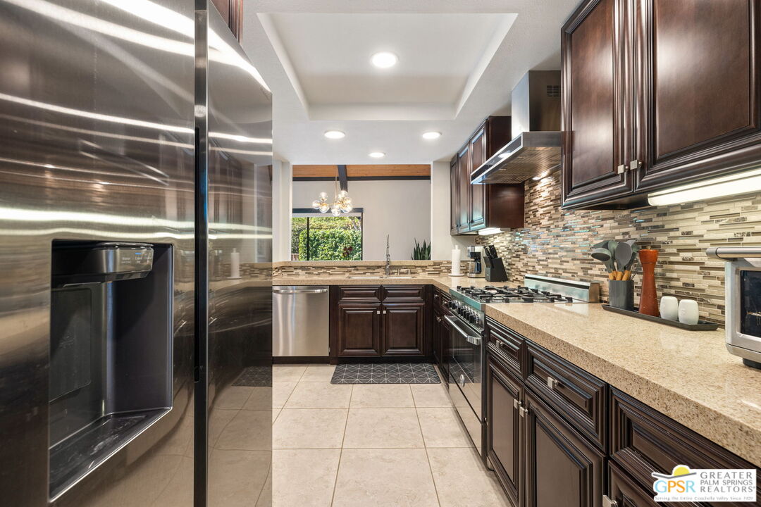 70100 Mirage Cove Drive, Unit 10 Rancho Mirage, CA 92270 - Photo 46 of 68 a kitchen with stainless steel appliances granite countertop a sink stove and refrigerator