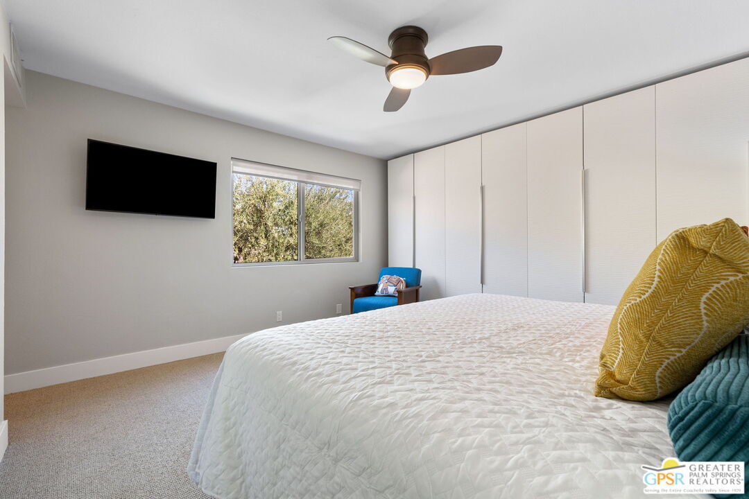 70100 Mirage Cove Drive, Unit 10 Rancho Mirage, CA 92270 - Photo 55 of 68 a bedroom with a large bed and a flat tv screen