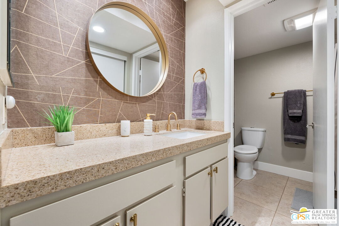 70100 Mirage Cove Drive, Unit 10 Rancho Mirage, CA 92270 - Photo 57 of 68 a bathroom with a granite countertop toilet a sink and mirror