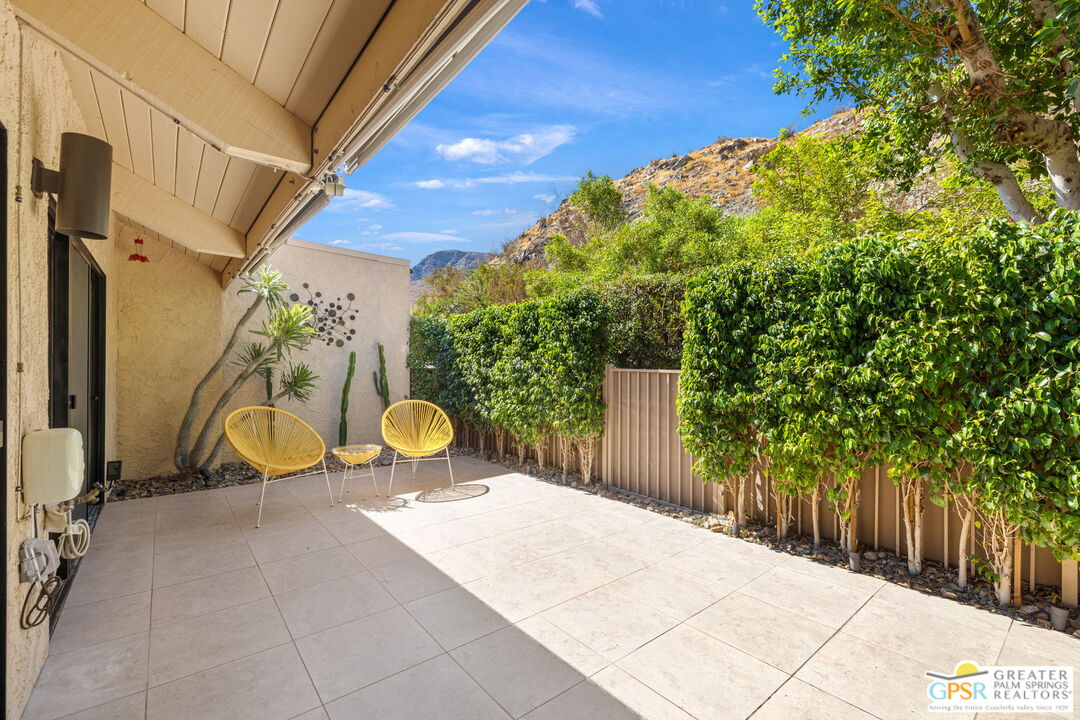 70100 Mirage Cove Drive, Unit 10 Rancho Mirage, CA 92270 - Photo 59 of 68 a view of a patio with table and chairs with wooden fence and plants